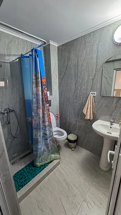 Baie modernă cu cabină de duș și lavoar în cameră