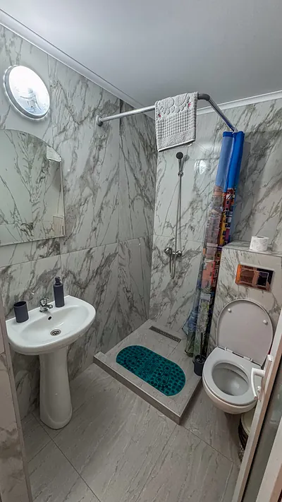 Baie placată cu marmură, cu duș și oglindă