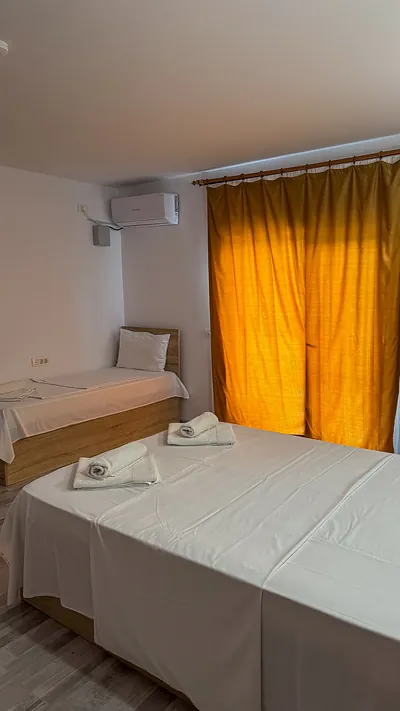 Detaliu cameră triplă: pat matrimonial și pat suplimentar single