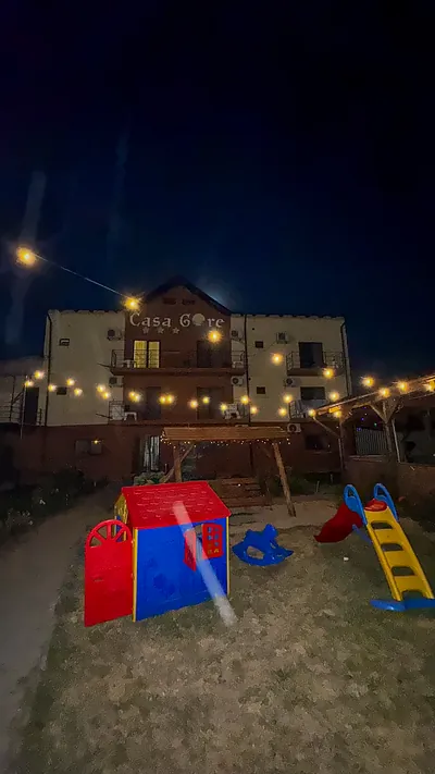 Curtea Casa Gore seara, cu ghirlande luminoase și locul de joacă pentru copii